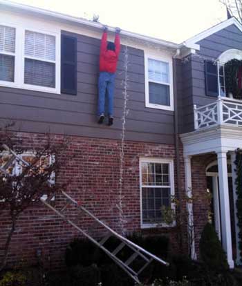 Guy holding onto roof after losing ladder